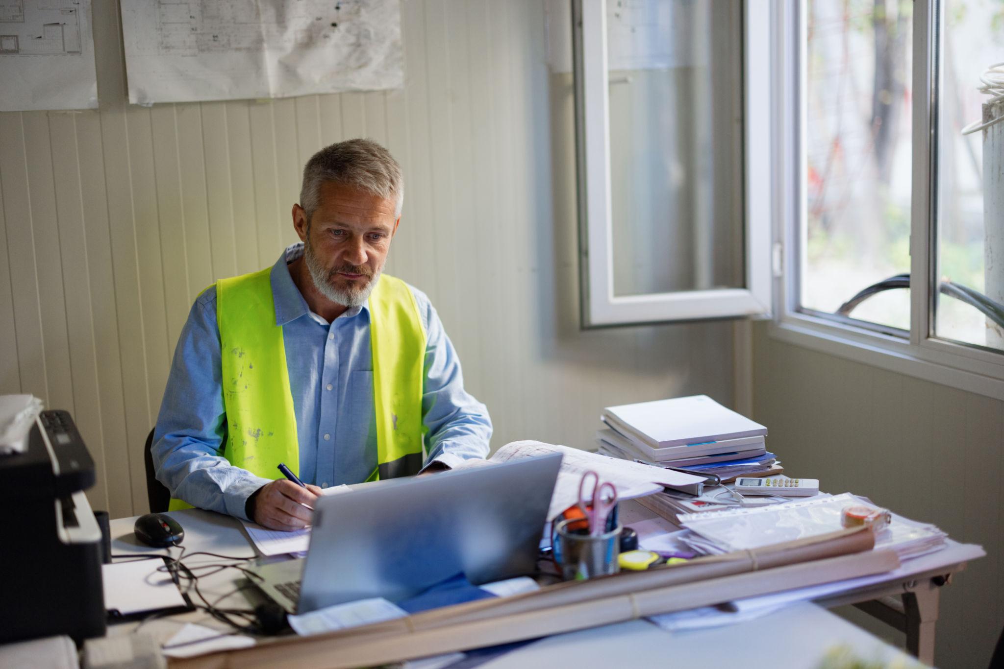 Person in safety vest using computer