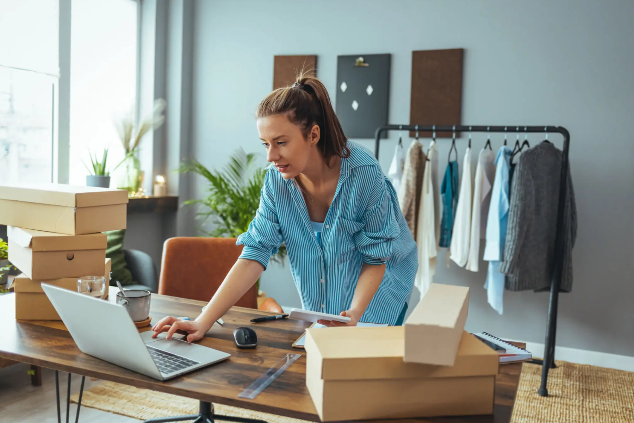 Woman managing online clothing orders at desk